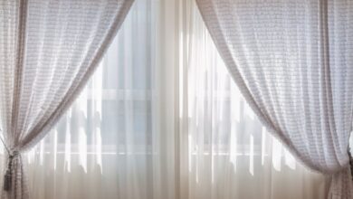 Curtains - Sun shining through elegant white curtains in a cozy, modern interior setting.