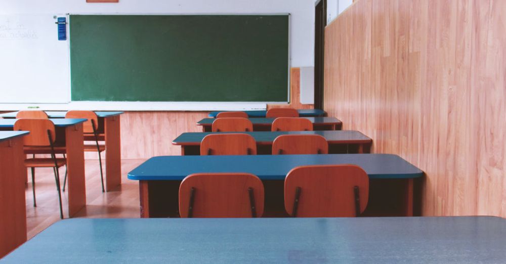 Desks - A tranquil empty classroom with wooden furniture and a green chalkboard, perfect for educational themes.