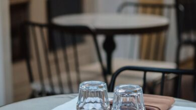 Dining Chairs - Cozy outdoor cafe table with glasses and napkins on a marble top, perfect for evening dining.