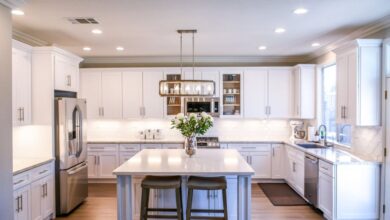 Kitchen Cabinets - Spacious and elegant kitchen featuring white cabinetry, island, and stainless steel appliances.