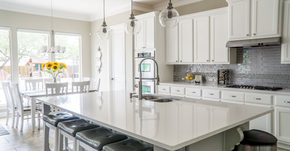 Cabinets - Spacious modern kitchen with white cabinets and island in natural light.