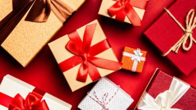 Gifts - Top view of beautifully wrapped holiday gifts with red and brown ribbons on a vibrant red background.