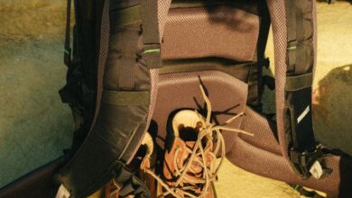 Backpacks - A backpack and boots arranged on a sandy surface, perfect for travel or adventure themes.