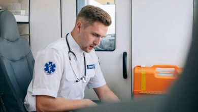 First Aid Kits - Focused paramedic in an ambulance setting, wearing uniform and stethoscope, ready for emergency response.