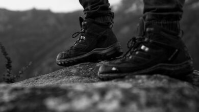 Hiking Boots - Close-up of hiking boots standing on a rock, showcasing outdoor adventure style in monochrome.