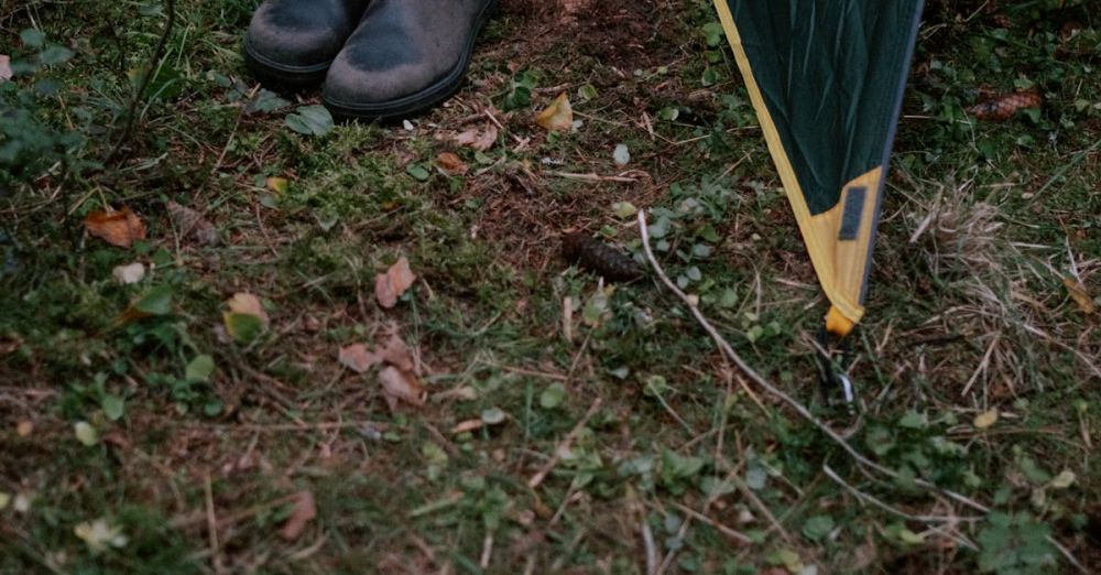 Tent Stakes - Outdoor camping scene with boots next to a tent on grassy ground.