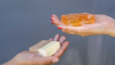 Cleansers - Close-up of hands holding different soap bars emphasizing personal hygiene and cleanliness.