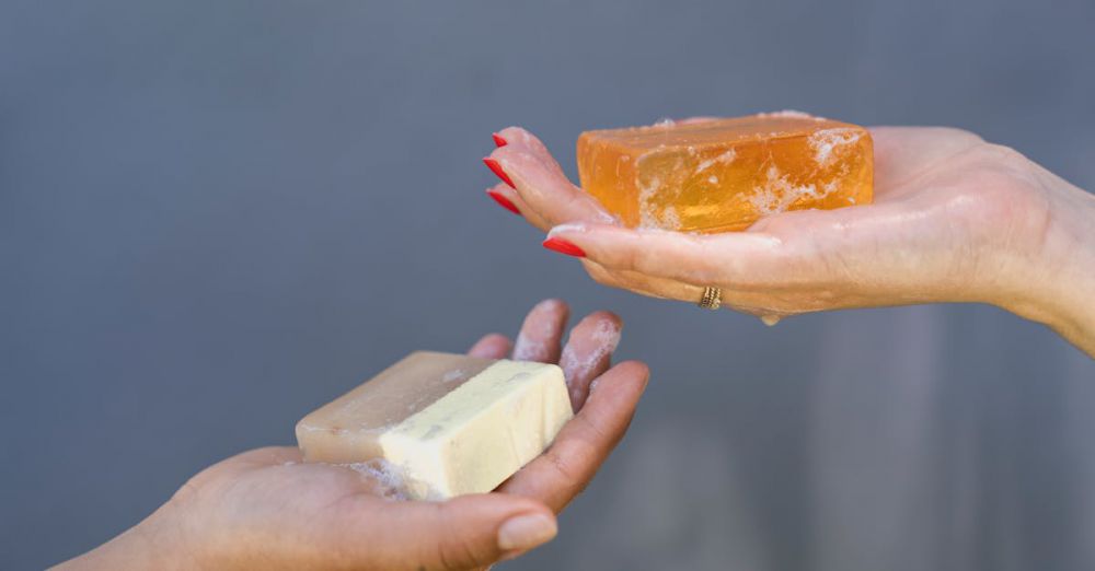 Cleansers - Close-up of hands holding different soap bars emphasizing personal hygiene and cleanliness.