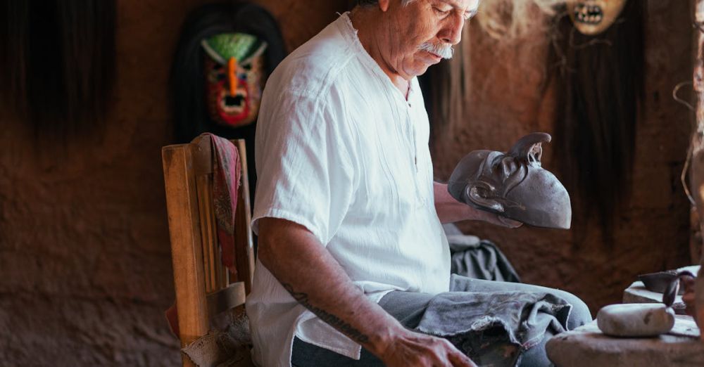 Clay Masks - Elderly artisan artist skillfully crafting clay masks in his workshop surrounded by vibrant cultural designs.