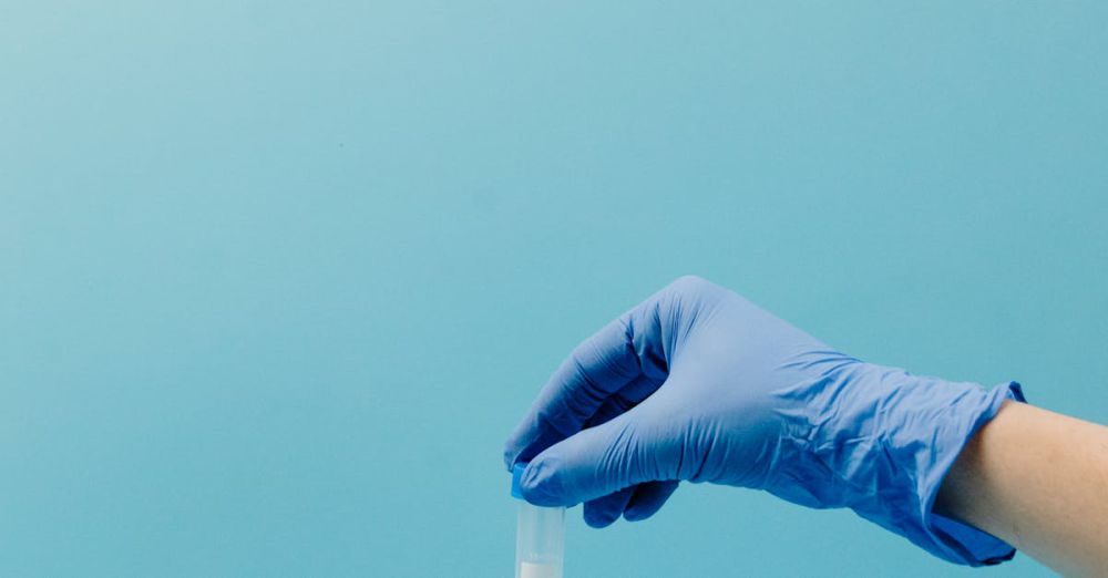 Frizz Control Products - A gloved hand picking up a test tube from a rack in a laboratory setting.