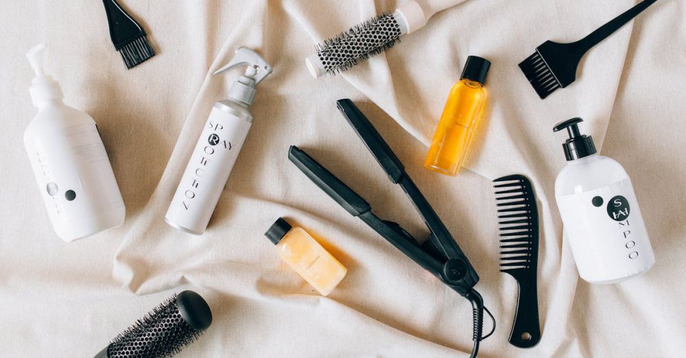 Leave-In Conditioners - Flat lay image of various hair care products and tools on a textured fabric surface.