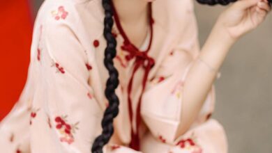 Hair Accessories - Smiling woman in floral dress with braids holding pomegranate basket, evoking tradition and joy.