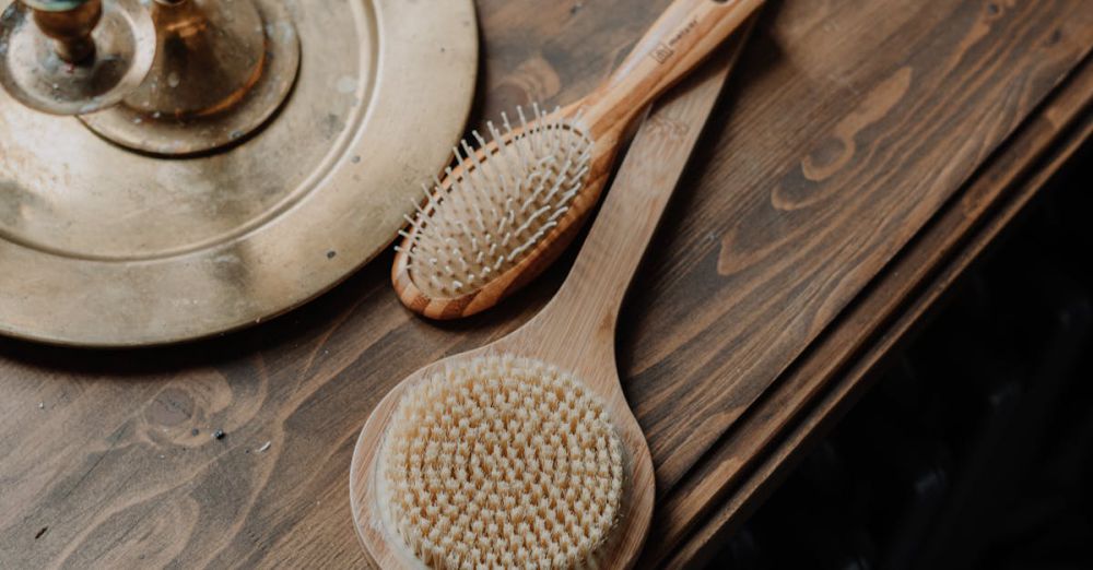 Hair Brushes - Wooden hair brushes and brass candle holder on a rustic wooden table.