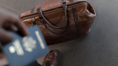 Luggage - Brown leather bag with passport in an airport setting, ideal for travel and fashion themes.