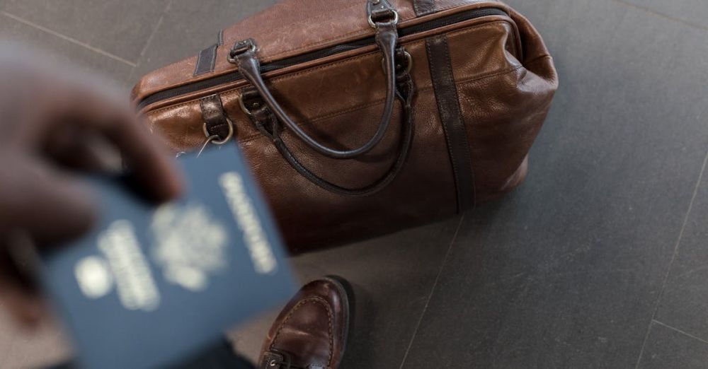 Luggage - Brown leather bag with passport in an airport setting, ideal for travel and fashion themes.