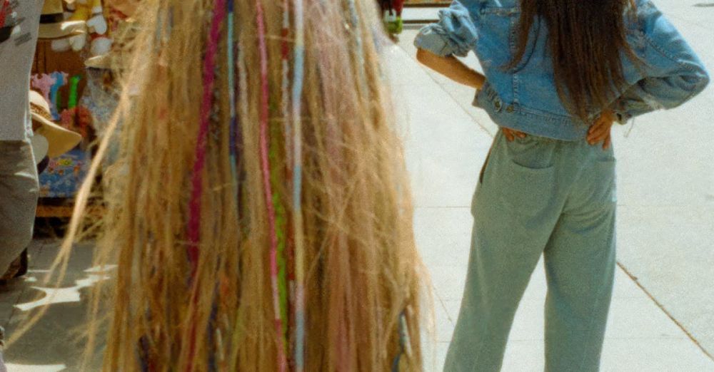 Hair Wraps - Vibrant hair wraps and hats on display at a sunny outdoor market near the beach.