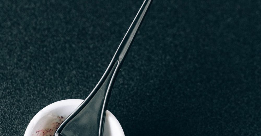 Hair Care Products - Close-up of a brush and mixing bowl for hair dye on a dark background.