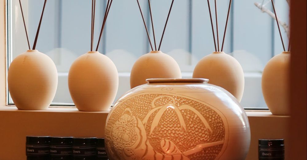 Diffusers - A serene indoor display of aromatherapy candles and diffusers on a wooden table by a window.