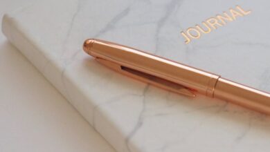 Journals - Minimalist marble journal with a gold pen, perfect for elegant stationery and writing inspiration.