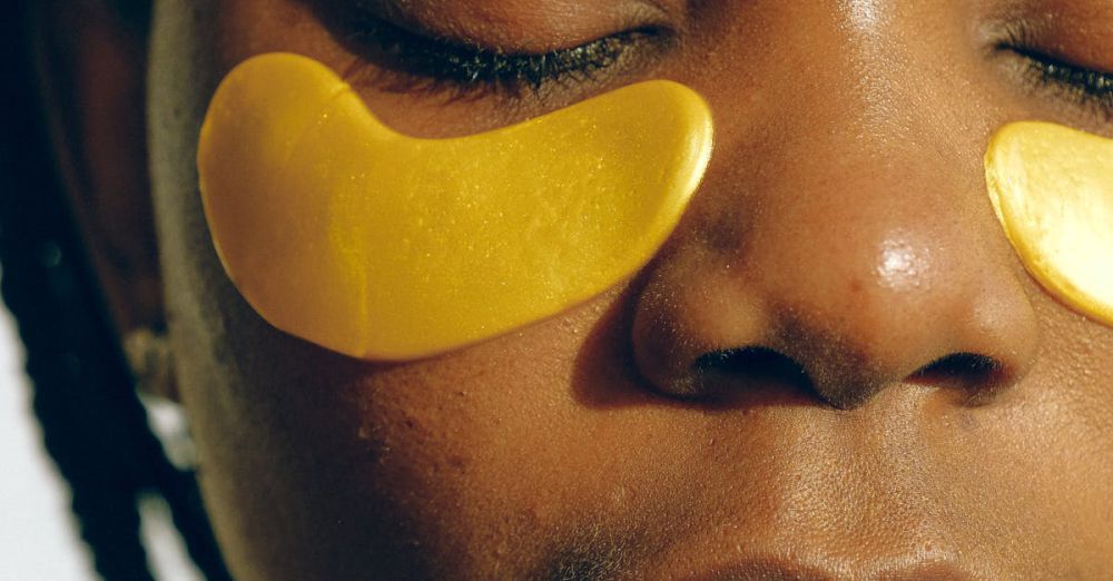 Eye Masks - Crop gentle African American female with closed eyes and clean face enjoying cosmetic procedure for smoothing and moisturizing skin under eyes and removing dark circles