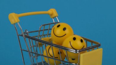 Stress Balls - Shopping cart filled with yellow smiley face stress balls on a vibrant blue background, with ample copy space.