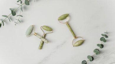 Massage Tools - Elegant jade facial rollers and eucalyptus leaves on marble surface, promoting a spa-like ambiance.