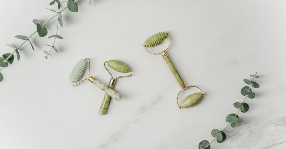 Massage Tools - Elegant jade facial rollers and eucalyptus leaves on marble surface, promoting a spa-like ambiance.