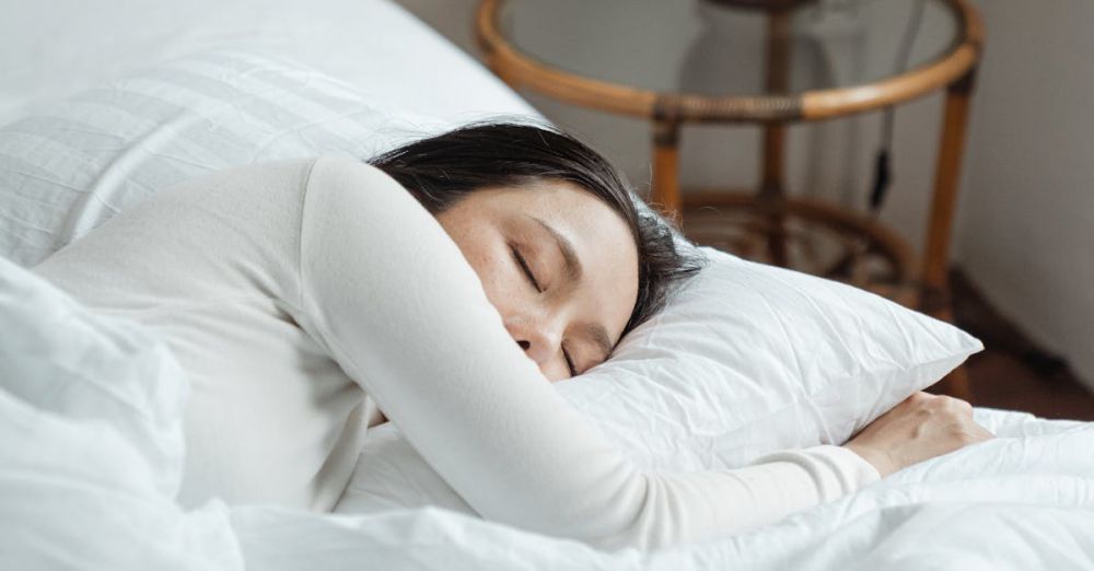 Eye Pillows - A serene scene of a woman sleeping peacefully on white bedding in a cozy bedroom.