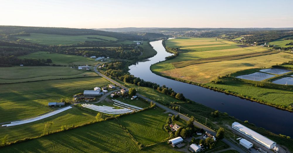 Roll-Ons - Drone capture of Quebec's picturesque farmland along a winding river at sunset.