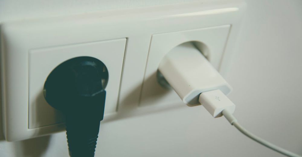 Adapter - A close-up view of a wall outlet with two plugs inserted, capturing the simplicity of electrical connectivity.