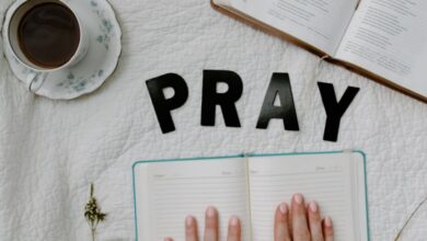 Wellness Journals - A serene flat lay featuring an open Bible, a journal, and a cup of coffee with the word 'PRAY'.