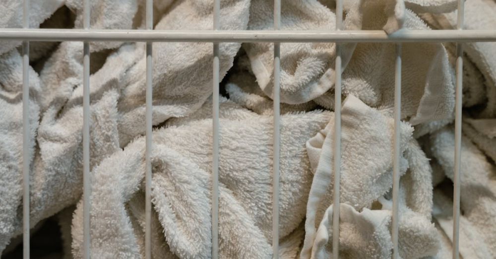 Cleaning Cloths - Close-up of white towels in a basket, highlighting textures and industrial setting.