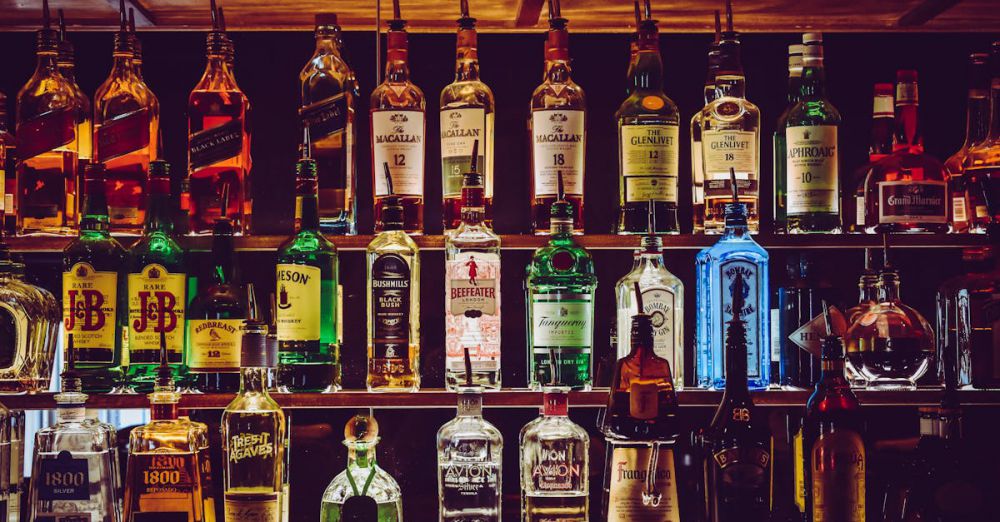 Bottles - An array of various liquor bottles beautifully displayed on a bar shelf.