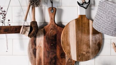 Cleaning Brushes - Charming wooden kitchenwares hang stylishly on a white tiled wall, perfect for rustic decor.