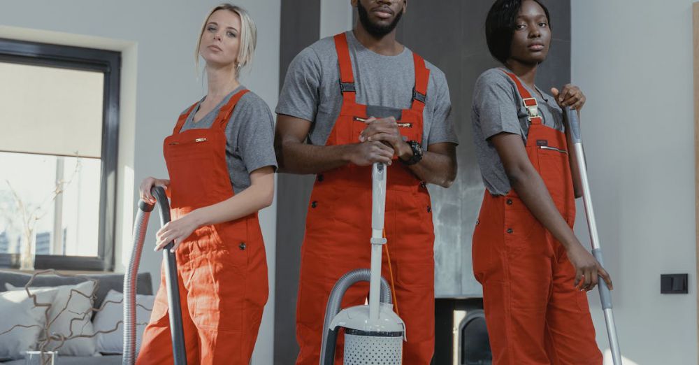 Mop Pads - Three cleaners in uniform with equipment in a modern home interior, showcasing teamwork and professionalism.