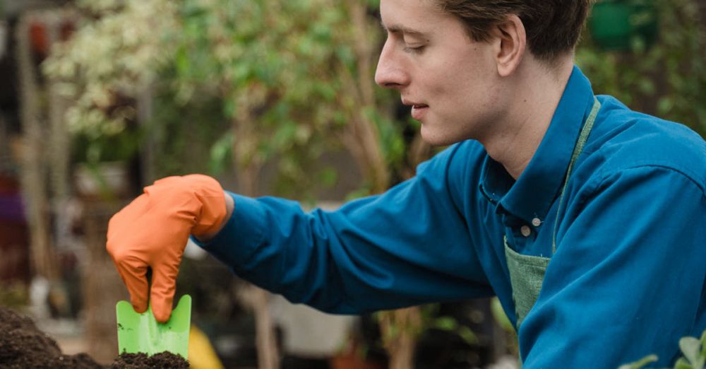 Gardening Gloves - A young gardener planting seedlings in a greenhouse, showcasing eco-friendly horticulture practices.