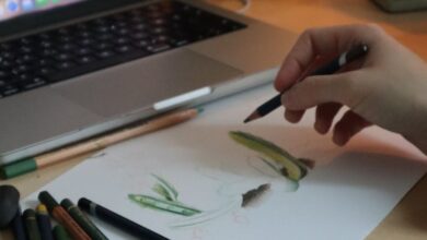 Drawing Pencils - Cozy workspace with drawing pencils, sketch, and laptop lighting a creative mood.