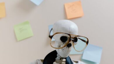 Post-It Notes - Humorous skeleton model with glasses and tie, illustrating burnout and overwork in office environment.