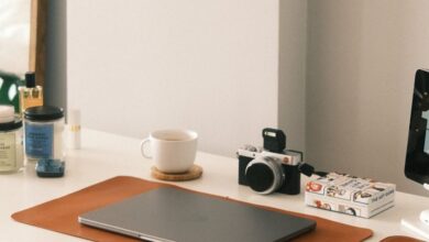 Desk Accessories - A clean and minimalist home office desk featuring a laptop, camera, and modern accessories.