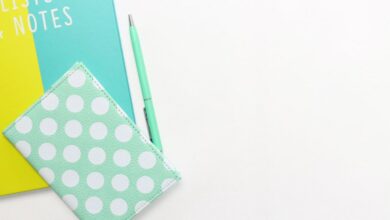 Diaries - Flatlay of a polka dot wallet, pen, and notebook with copyspace on a white background.