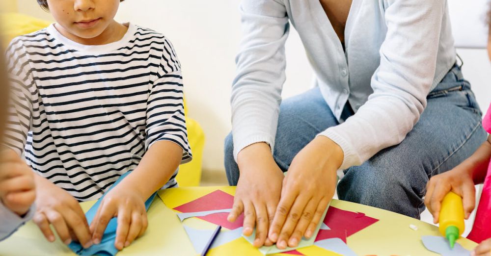 Glue Sticks - Children and teacher engaging in creative arts and crafts activities indoors.