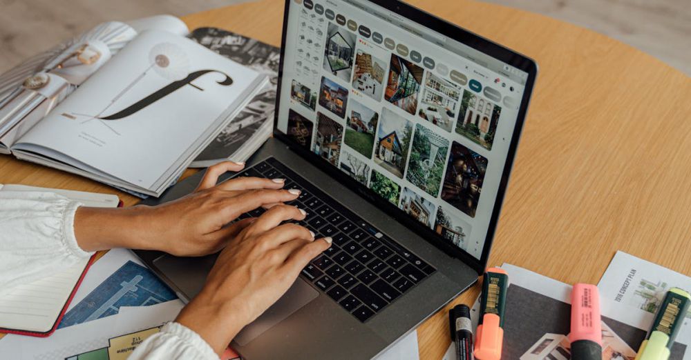 Highlighters - A person working from home with a laptop, coffee, and magazines on a wooden table, showcasing a freelancing lifestyle.