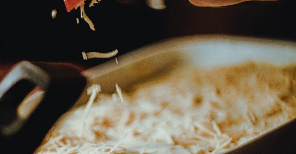 Shredders - A chef grates cheese over a dish, capturing a rustic kitchen ambiance.