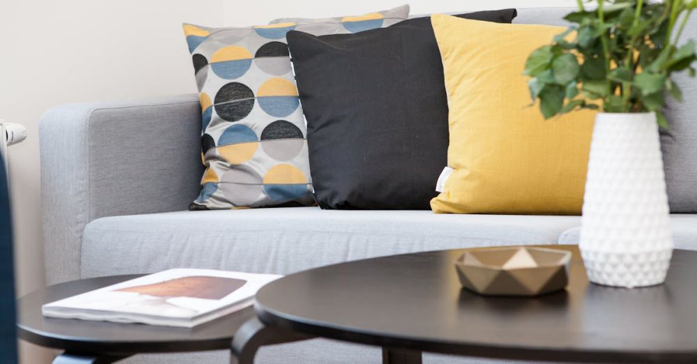 Pillows - Contemporary living room interior featuring a stylish sofa, decorative pillows, and a vase of flowers.