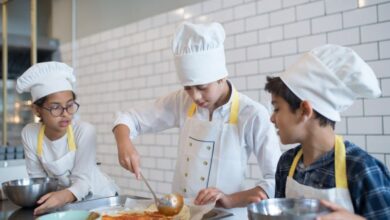 Mixing Bowls - Young aspiring chefs in Portugal make pizza, spreading tomato sauce enthusiastically in a fun cooking class.