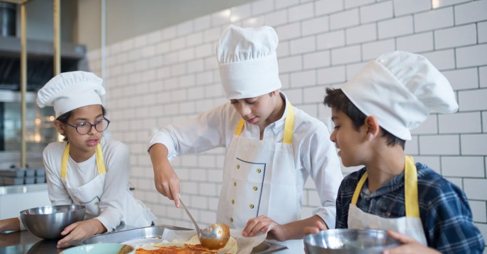 Mixing Bowls - Young aspiring chefs in Portugal make pizza, spreading tomato sauce enthusiastically in a fun cooking class.