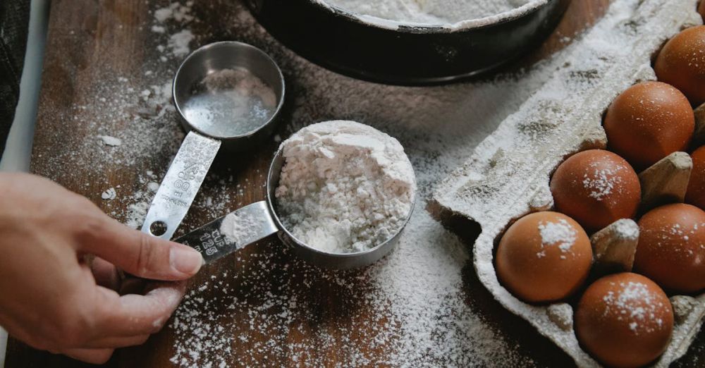 Measuring Cups - Hands preparing dough with flour and eggs in a kitchen setting.