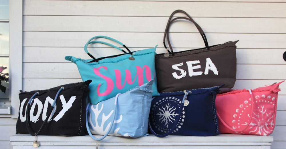 Bags - Vibrant collection of beach bags arranged on a white wooden table against a panel wall.