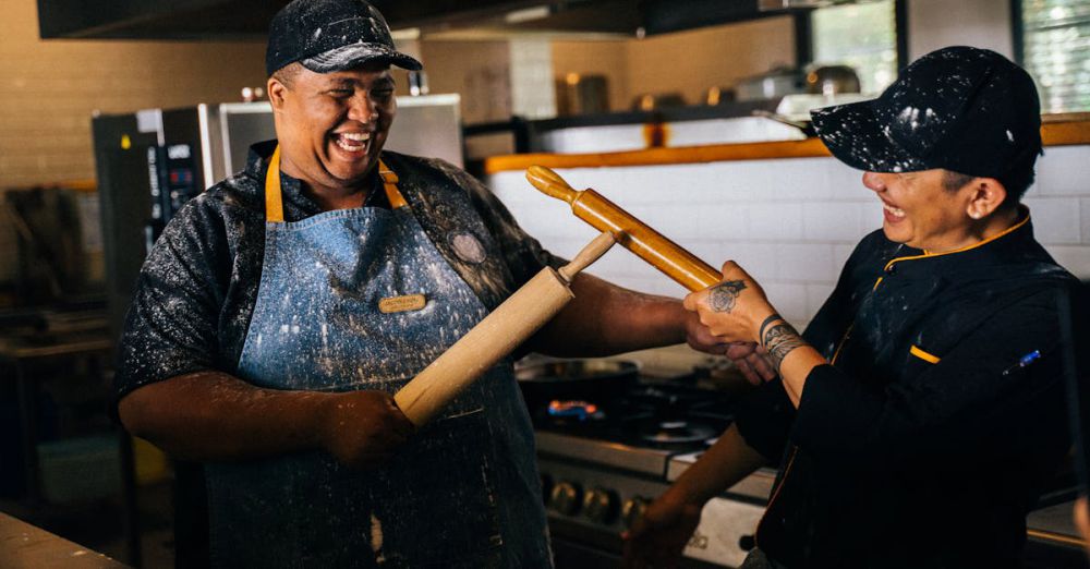 Rolling Pins - Two chefs having fun in a restaurant kitchen with rolling pins.