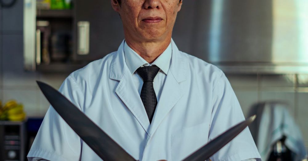 Chef Knives - Portrait of an Asian chef holding knives in a Tokyo restaurant kitchen.